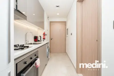 Galley kitchenette with gas hob, oven and coffee machine by the entry