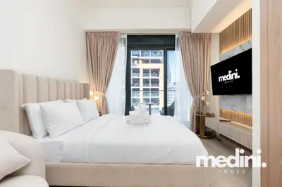 Studio bed beside a slatted wood feature wall with mounted TV