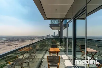 High-floor balcony with timber bistro sets and sweeping desert views