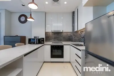 U-shaped kitchen with gas hob, oven, fridge and marble splashback