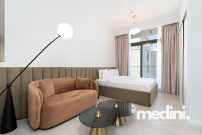 Curved velvet sofa and globe floor lamp beside the double bed