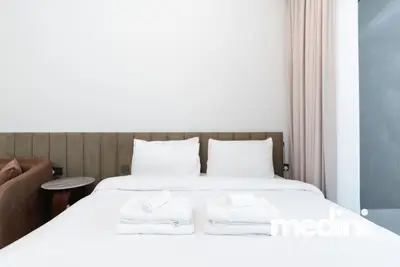 Fresh towels stacked on the crisp white double bed