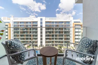 Furnished balcony with two patterned chairs and a small side table