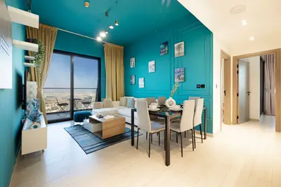 Open plan living and dining area under a bold teal ceiling and panelled walls