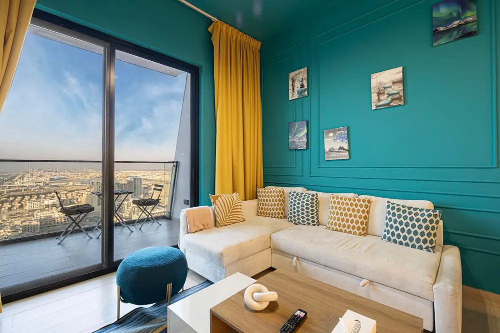 Colourful living room with teal panelled walls, corner sofa and floor to ceiling window