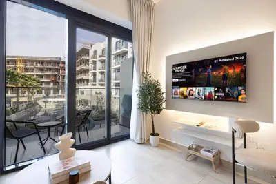 Open-plan living room with sliding glass doors to balcony and city view