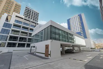 Building exterior showing glass ground-floor frontage and surrounding towers