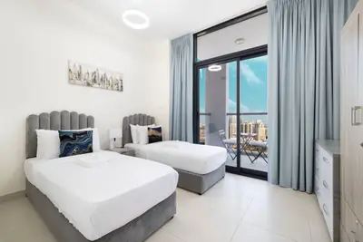 Twin bedroom with two single beds and a sunny balcony just outside