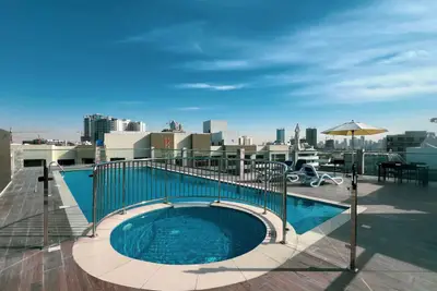 Rooftop pool and circular jacuzzi with open city skyline above