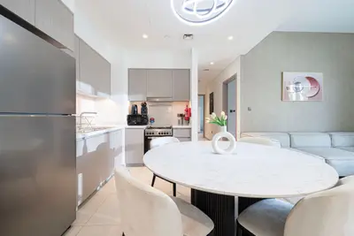 Open kitchen and round marble dining table flowing into the lounge area