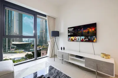 Living room corner with wall-mounted smart TV and floor-to-ceiling windows