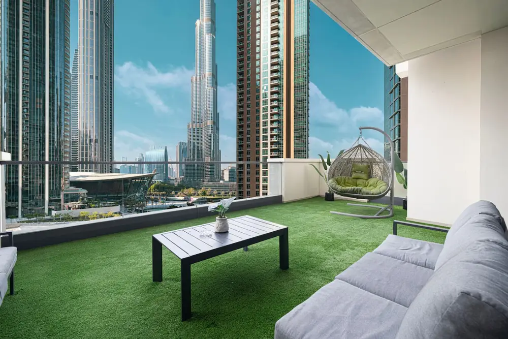 Furnished terrace with artificial grass, egg chair and a Burj Khalifa view