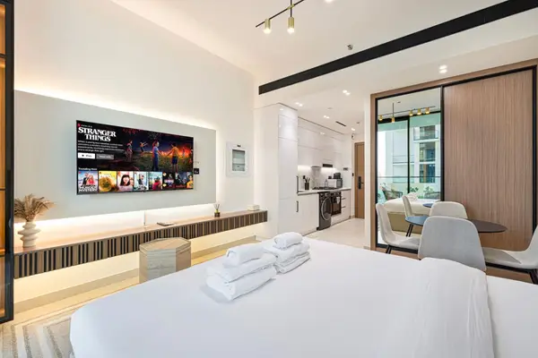 Studio with double bed, wall-mounted TV, kitchen and dining area all in one open room