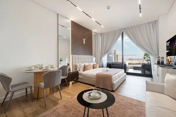 Open studio with double bed, dining table and floor-to-ceiling city-facing window