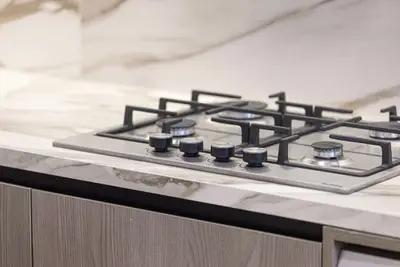 Four-burner gas hob set into a marble-effect kitchen countertop