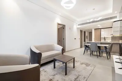 Open-plan living room with sofa, coffee table, and dining area behind