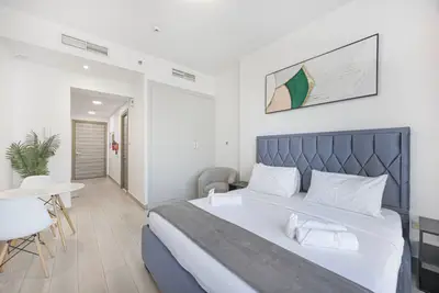 Another view of the bedroom with dining corner, plant, and hallway