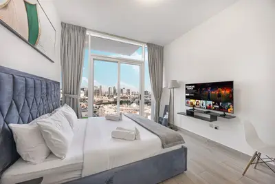 The bedroom seen from the foot of the bed with skyline through the large window