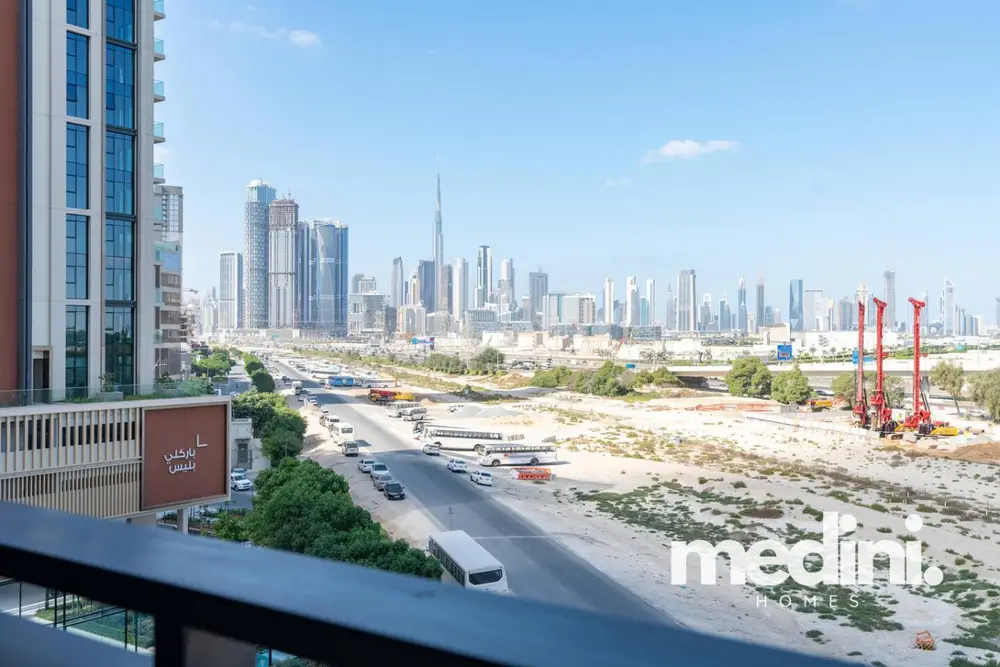 Balcony view over a main road toward the skyline with the Burj Khalifa visible