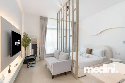 Studio with slatted wood divider separating the bed from the TV wall and sofa