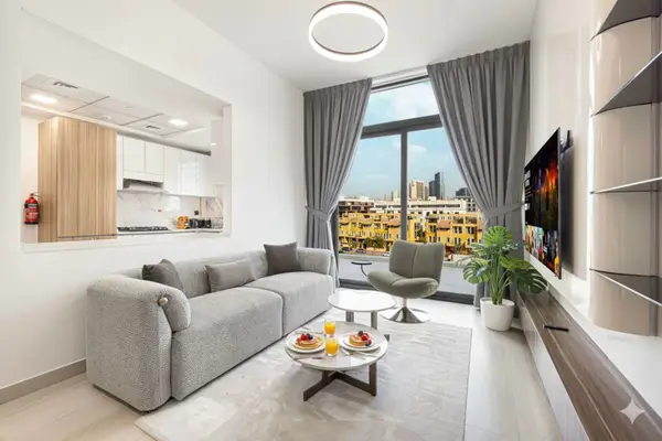 Living room with grey sofa, wall-mounted TV, and city-view window