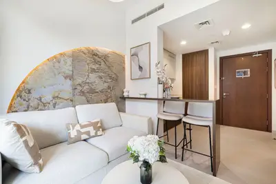 Living room from the entrance with a stone-panel wall accent and bar stools