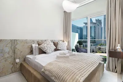 Bedroom with a double bed, marble-look headboard panel and a glazed door to the balcony