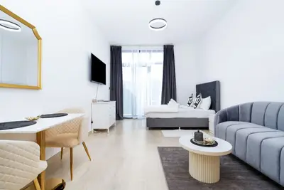 Studio from the dining corner with the sofa, coffee table and a wall-mounted TV