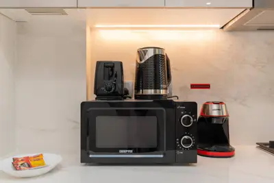 Kitchen counter with microwave, toaster, kettle, and coffee maker