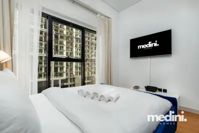 Bedroom seen from the side showing wall-mounted TV and tall windows