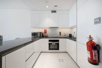 White U-shaped kitchen with dark countertops, oven, and countertop appliances