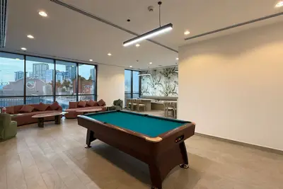 Games room with a full-size pool table and seating area by large windows