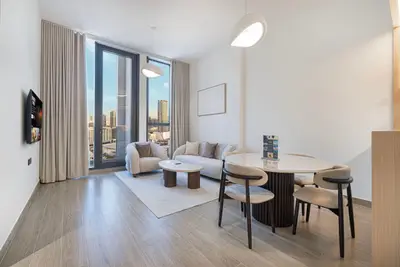 Living and dining area with sofa, round table, and floor-to-ceiling windows