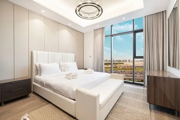 Master bedroom with upholstered headboard and floor-to-ceiling window