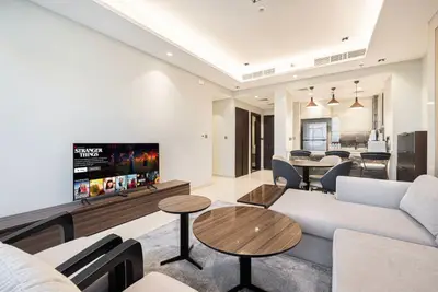 Living room with sectional sofa, flat-screen TV, and view toward the dining area