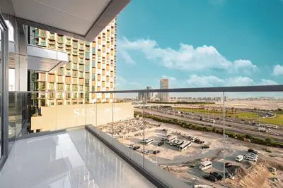Glass-railed balcony with highway and construction site view below