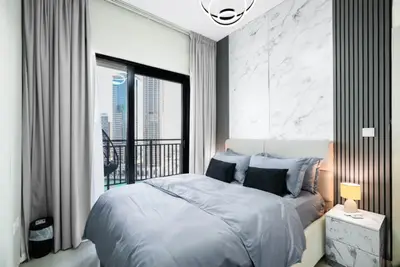 Bedroom with double bed, marble-panel headboard, and floor-length balcony curtains