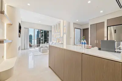 Kitchen island with warm wood cabinetry and open view into the living area