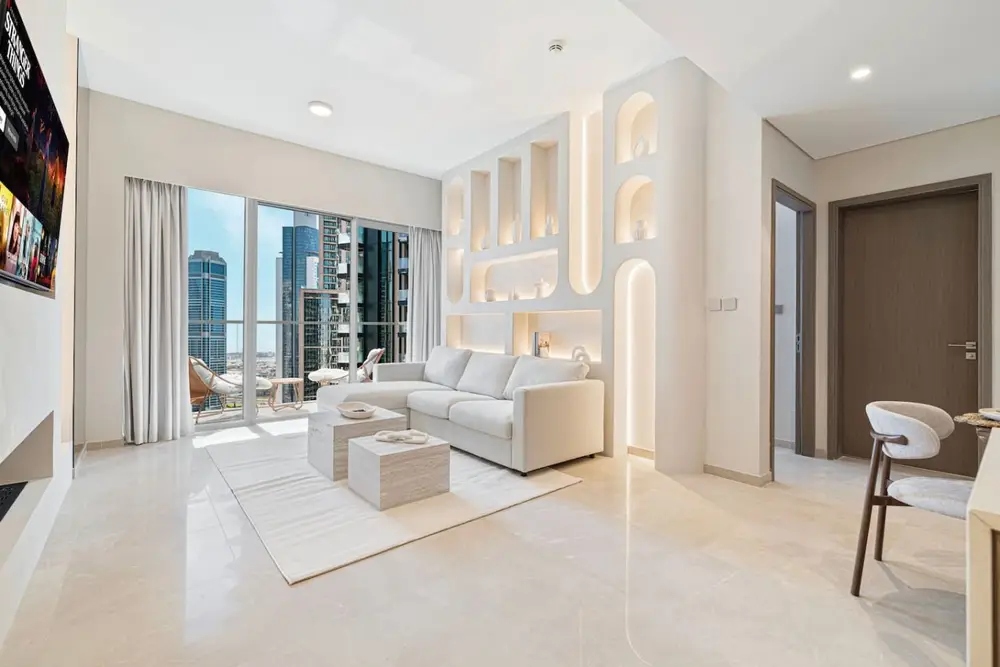 Bright living room with arched wall niches, sectional sofa, and city skyline views