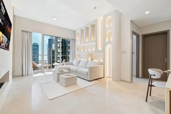Bright living room with arched wall niches, sectional sofa, and city skyline views