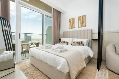 Bedroom with king bed, folded towels, and balcony sliding door