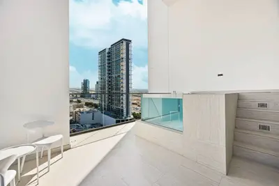 Balcony with glass-rail plunge pool overlooking city towers