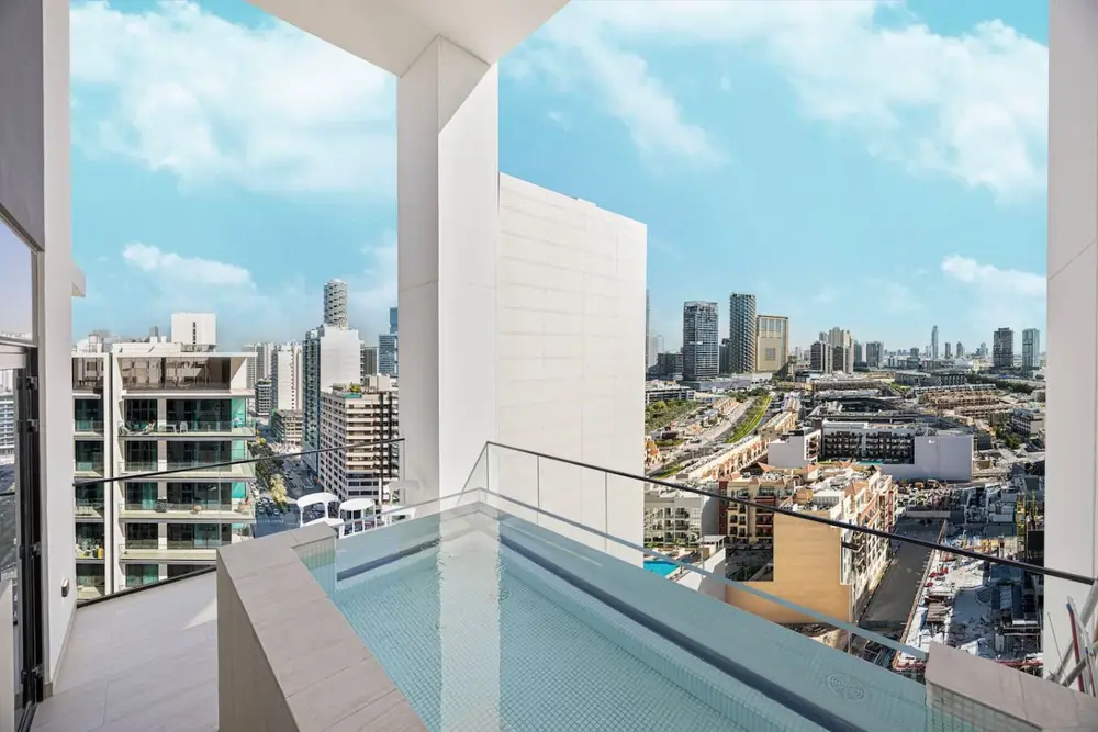 Private balcony plunge pool with open city views and blue sky