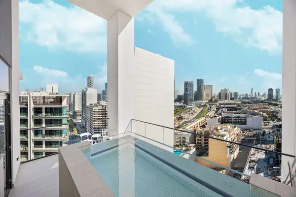 Private balcony plunge pool with open city views and blue sky