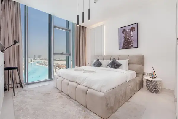 Bedroom with king bed and floor-to-ceiling window overlooking a lagoon