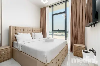Master bedroom with tufted king bed and floor-to-ceiling window overlooking open land