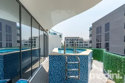 Private pool terrace with metal ladder, hedgerow privacy screen and building views