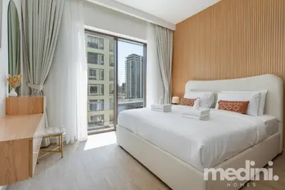 Bedroom with king bed, wood-slat feature wall, and tower view through glass door