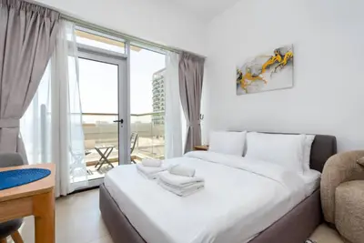 Bed with rolled towels and French doors opening to the balcony