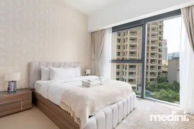 Another bedroom angle with a tree-lined street and residential tower outside